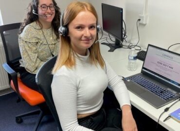 Two DA helpline advisors are at their desks ready to take calls.